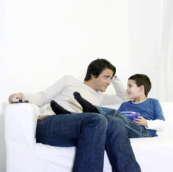 Father and son sitting on the couch chatting