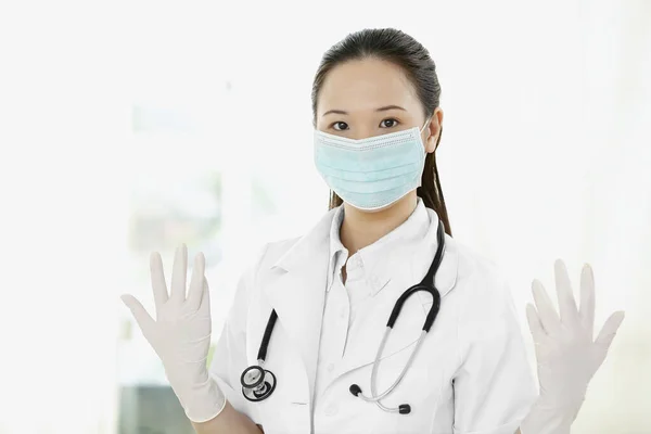 Female doctor with surgical gloves and mask