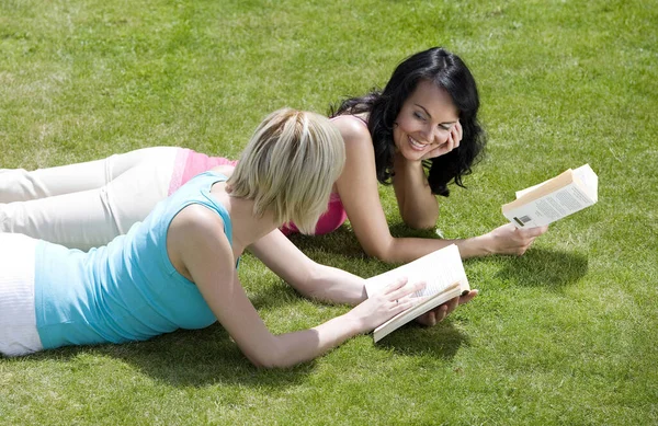 Två Kvinnor Som Ligger Parken Och Läser Böcker — Stockfoto