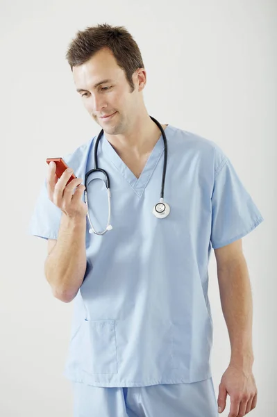 Médico Masculino Lendo Mensagem Texto Seu Telefone Celular — Fotografia de Stock