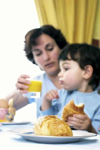 女と息子が食卓で朝食をとる — ストック写真