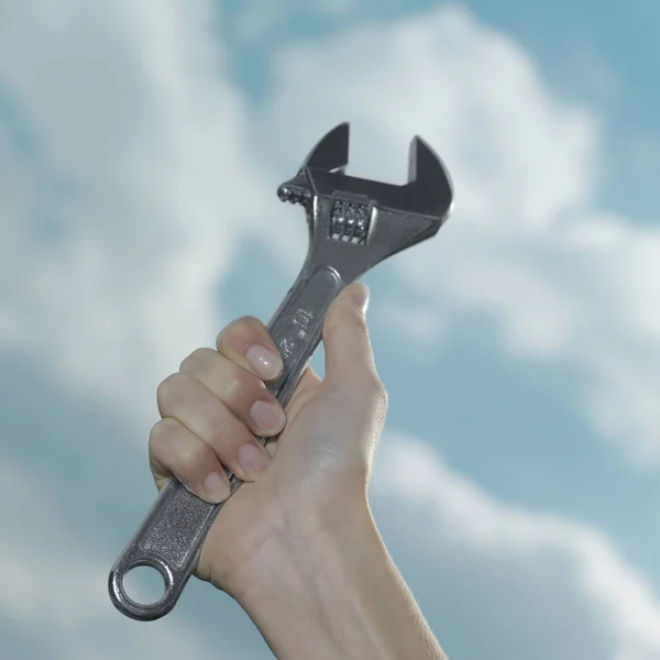 Woman's hand holding an adjustable wrench