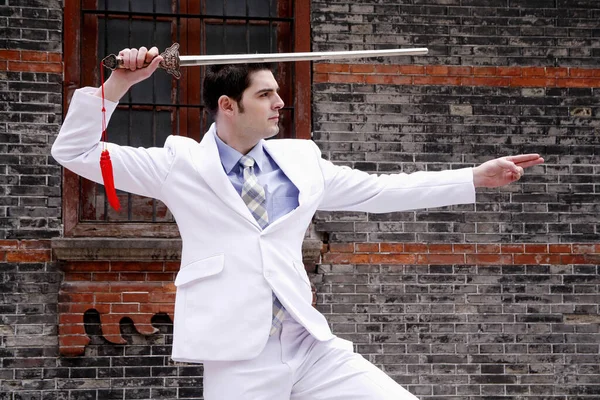 Businessman practicing kung fu with a Chinese sword