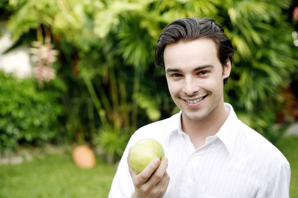 Mężczyzna Trzymający Zielone Jabłko Uśmiechając Się Kamery — Zdjęcie stockowe