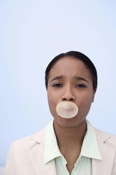 Businesswoman blowing bubble gum