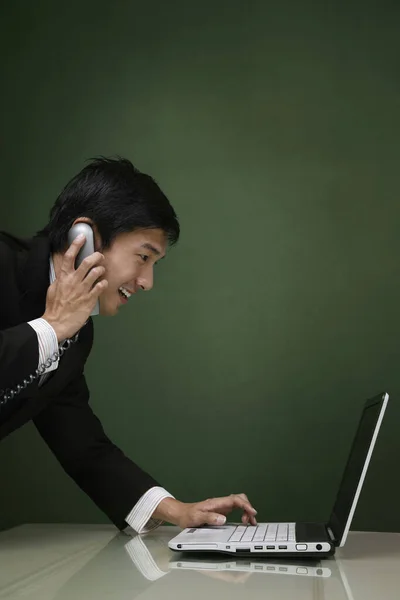 Empresario Hablando Por Teléfono Mientras Usa Portátil —  Fotos de Stock