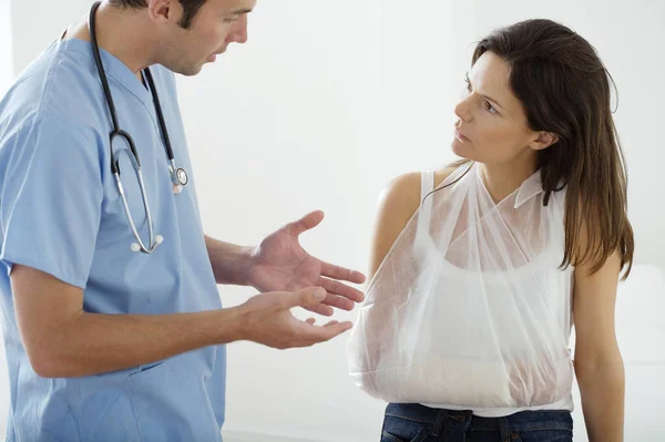 Männlicher Arzt Erklärt Patientin Ihren Gebrochenen Arm — Stockfoto
