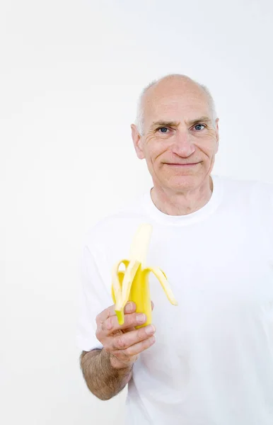 皮をむいたバナナのシニア男 — ストック写真