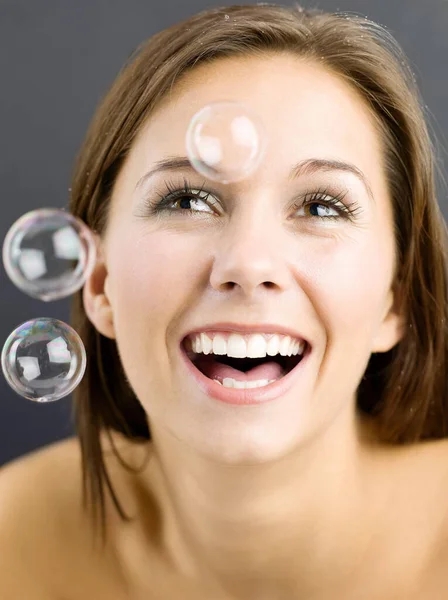 Mujer Sonriente Mirando Burbujas —  Fotos de Stock