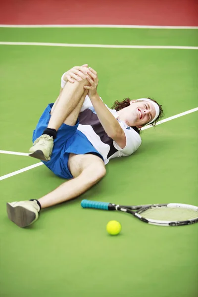 テニスをしながら膝を負傷した男 — ストック写真