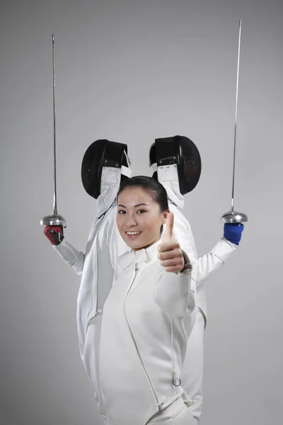 Woman and two men in fencing suits posing for the camera