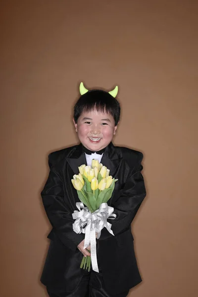 Αγόρι Σμόκιν Και Κέρατα Διαβόλου Κρατώντας Ένα Μπουκέτο Λουλούδια — Φωτογραφία Αρχείου