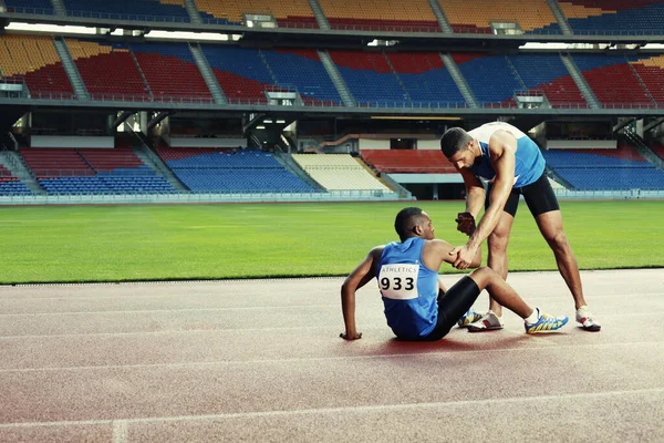 Hombre Atleta Tendido Pista Apretando Pierna Dolor Otro Atleta Ayudando — Foto de Stock