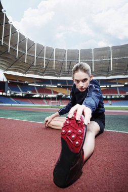 Bayan sporcu koşu pistinde ısınıyor.