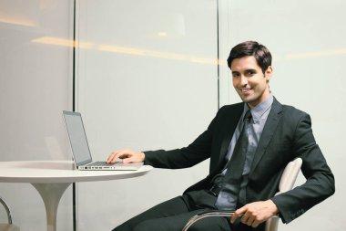 Ofiste dizüstü bilgisayar kullanan bir iş adamı