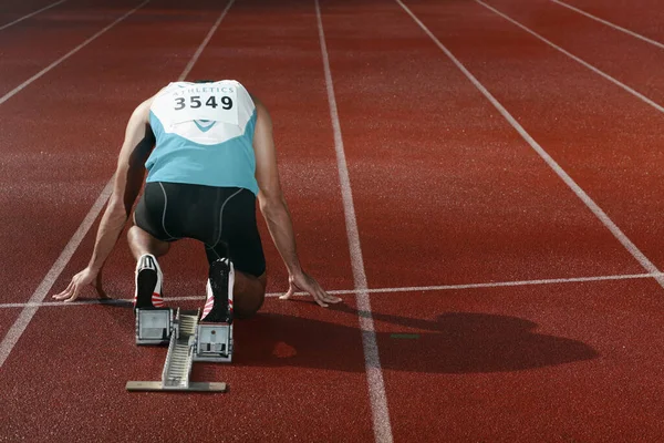 Male athlete crouching on starting line