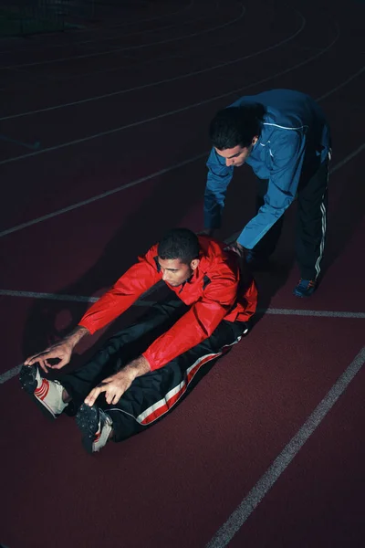 Entrenador Deportivo Ayudando Atleta Masculino Estirar Cuerpo — Foto de Stock