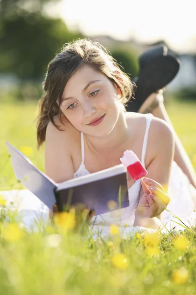 Meisje Dat Een Boek Leest Terwijl Een Ijslolly Eet — Stockfoto