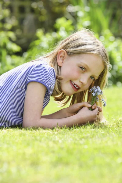 Девушка Лежит Траве Держа Цветы — стоковое фото