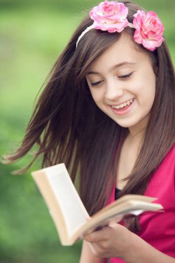 Dışarıda kitap okuyan bir kız.