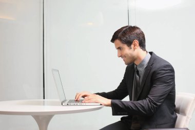 Ofiste dizüstü bilgisayar kullanan bir iş adamı