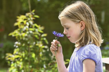 Gözleri kapalı çiçek kokan bir kız.