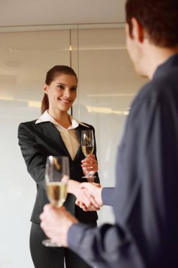 Şampanya içip el sıkışan iş adamları.