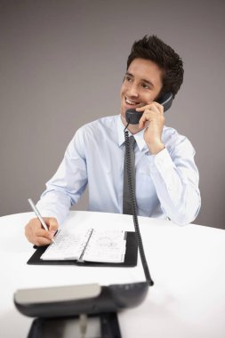 İş adamı telefonda konuşurken organizatöre yazı yazıyor