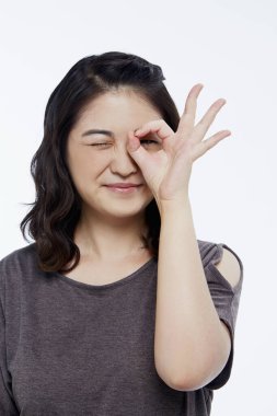 Neşeli bir kadın el hareketi yapıyor.
