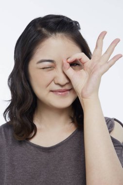 Neşeli bir kadın el hareketi yapıyor.