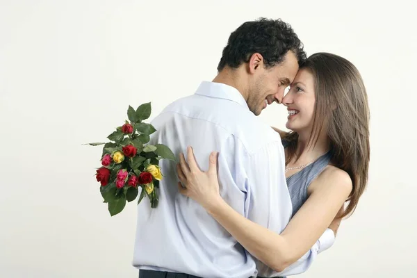 Mujer Abrazando Hombre Por Darle Ramo Flores Imagen de stock