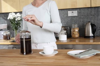 Kadın mutfakta kahve hazırlıyor.