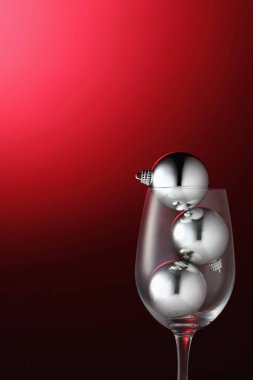 Şarap kadehinde Noel mücevherleri. Yakın plan.