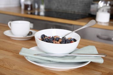 Bir kase kahvaltı gevreği ve mutfak tezgahında bir fincan kahve.