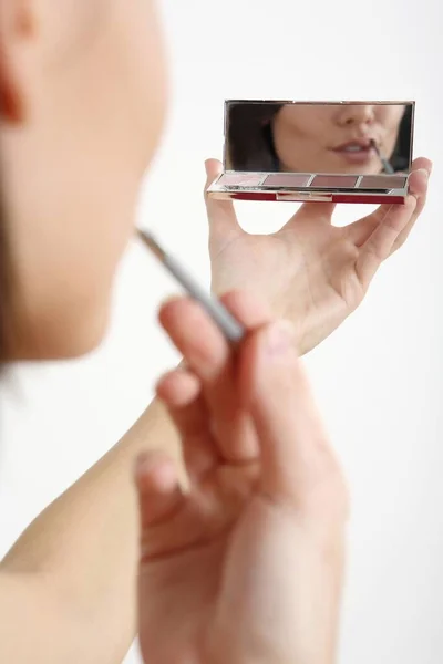 Donna Guardando Specchio Compatto Mentre Colorava Labbra — Foto Stock
