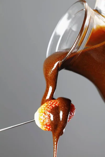 在草莓上倒入巧克力糖浆 — 图库照片