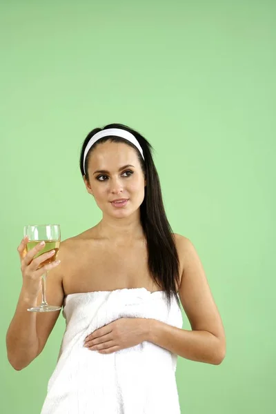 女人拿着一杯香槟裹在毛巾里 — 图库照片