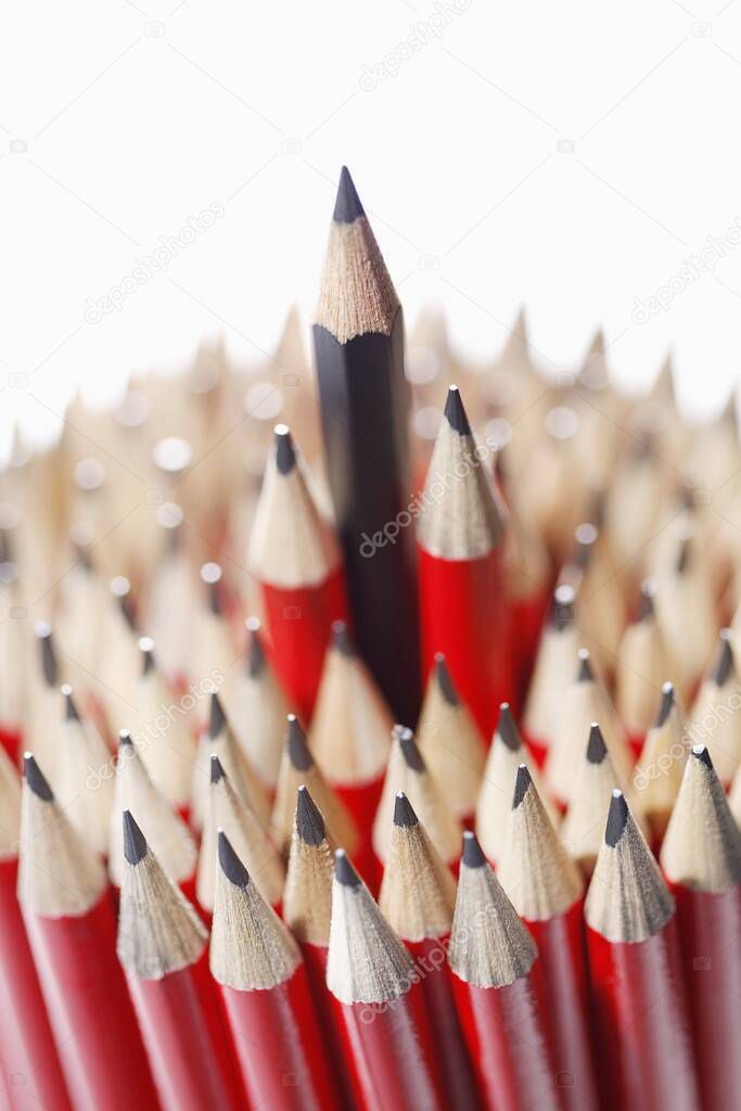 Blue pencil among bunch of red pencils