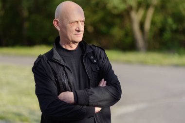 Çimlerin üzerinde duran yaşlı bir adam