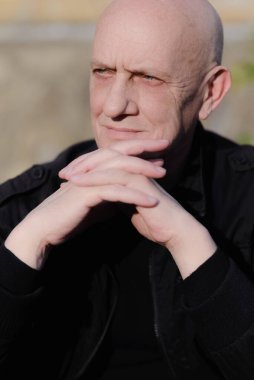 Mavi gözlü yaşlı bir adam başka tarafa bakıyor.