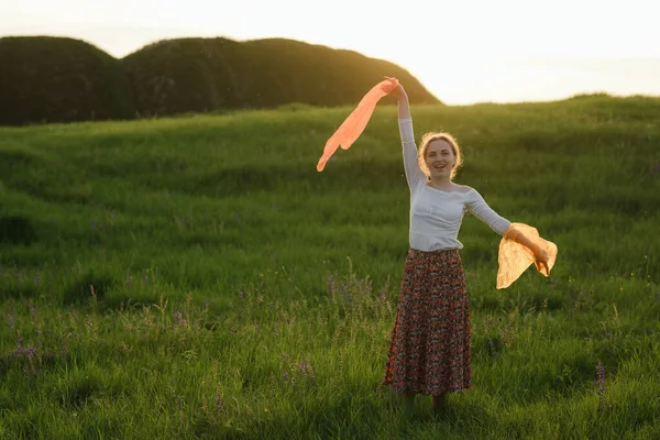 Hermosa chica pelirroja se divierte y baila en un campo al atardecer — Foto de Stock
