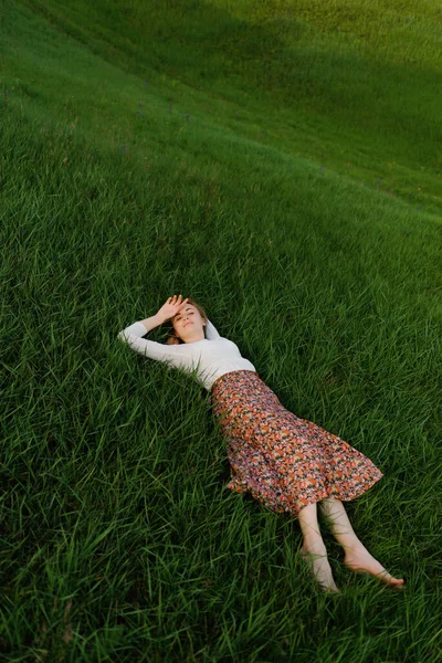 Mladá žena odpočívá v trávě Stock Obrázky