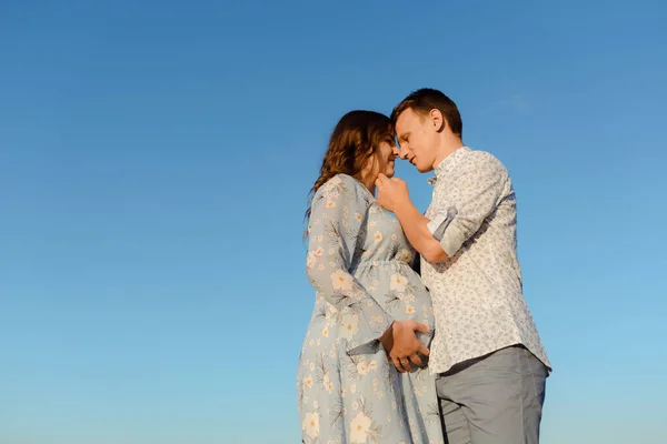 Futuro mamá y papá besándose en el parque al atardecer —  Fotos de Stock