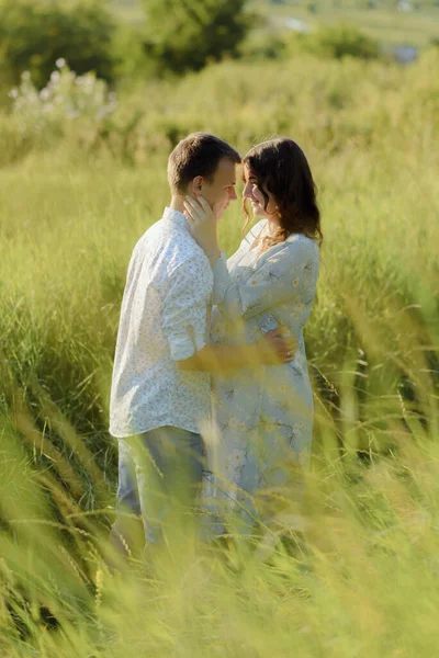 Futuro mamá y papá besándose en el parque al atardecer —  Fotos de Stock