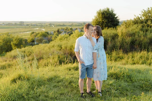 Una mujer embarazada camina en el campo con su marido —  Fotos de Stock