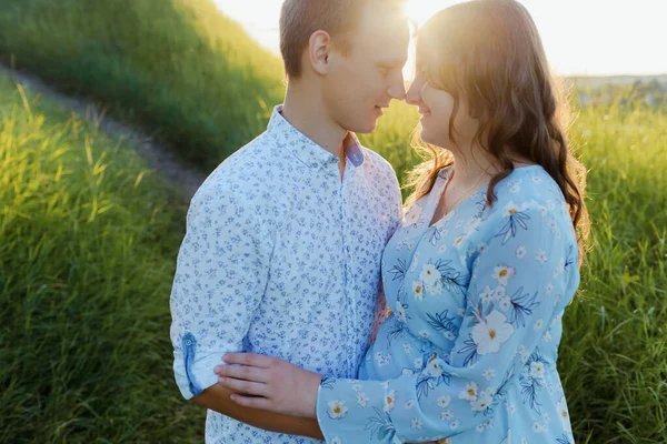 Pregnant woman is kissing with her husband at sunset. — Stock Photo, Image