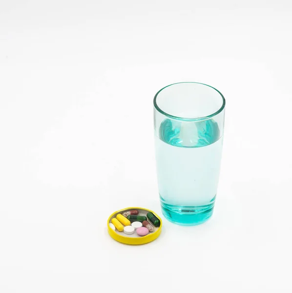 Bir bardak su ve ilaç.
