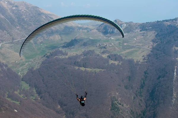 Paraşütçü dağların üzerinden uçuyor. İtalya