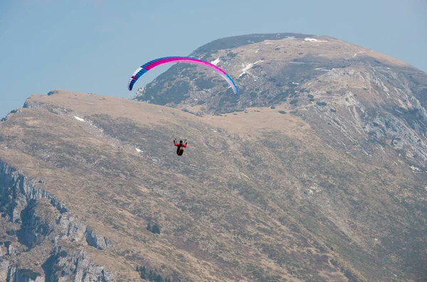 Paraşütçü dağların üzerinden uçuyor. İtalya