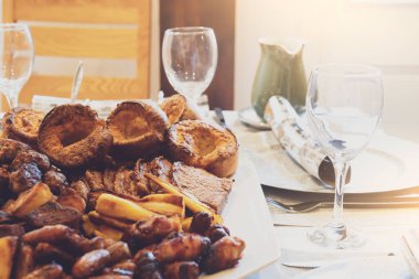 Pazar öğle yemeği, soslu ev yapımı biftek, kızarmış patates ve Yorkshire pudingi geleneksel İngiliz yemeği, Noel günü aile veya arkadaşlarla parti için Noel yemeği fikirleri.